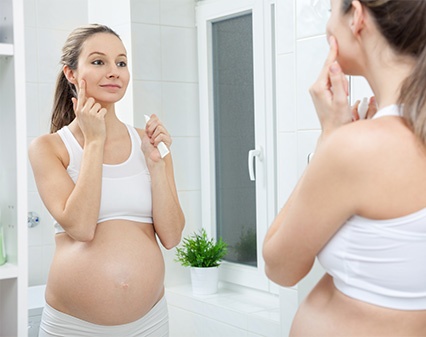 pregnant woman using face lotion